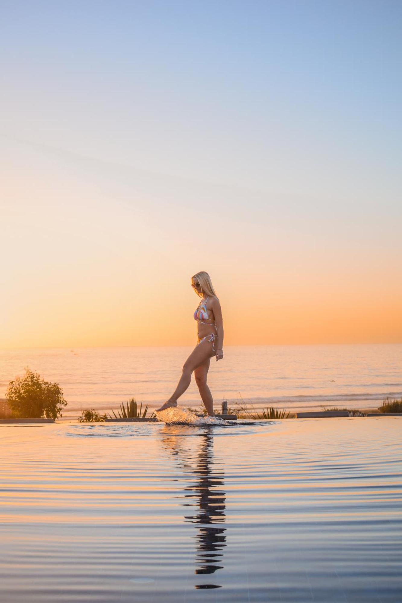Hyatt Regency Taghazout Hotel Exterior photo A woman walking on a skimboard